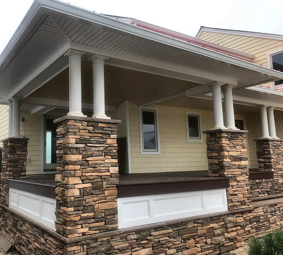 Covered porch with paired round columns on stacked stone piers