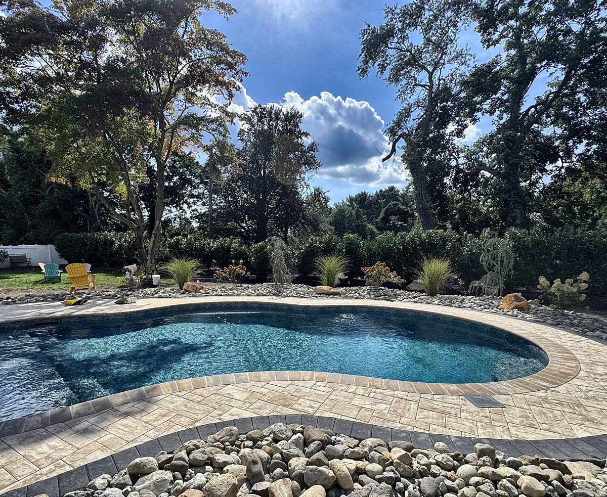 Backyard pool with paver patio, stone border and new plantings