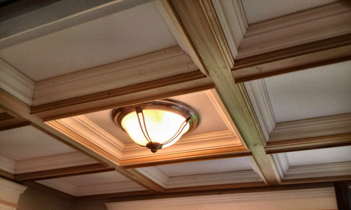 Coffered ceiling with layered crown molding and trimmed door casings
