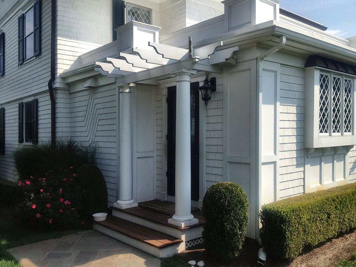 Side entry with round columns under a stepped pergola